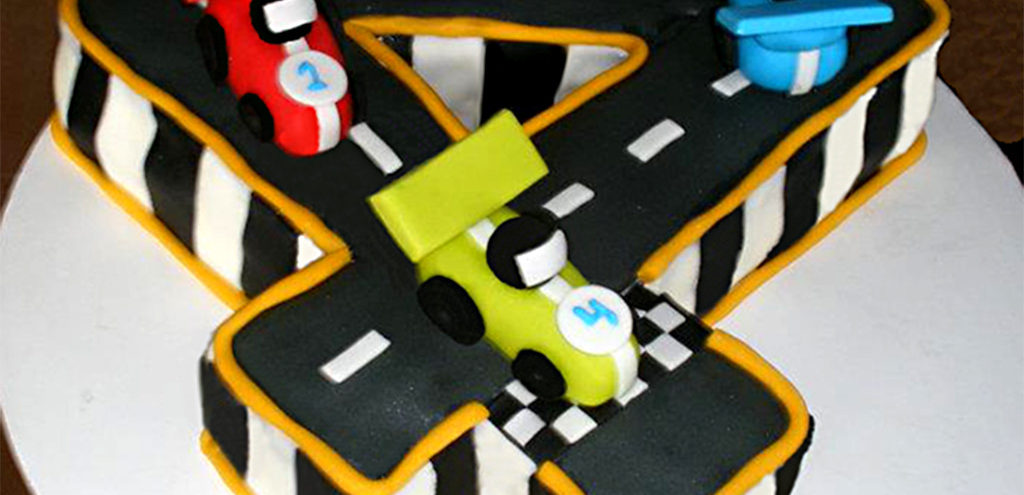 a cake in the shape of a 4 with four racecars