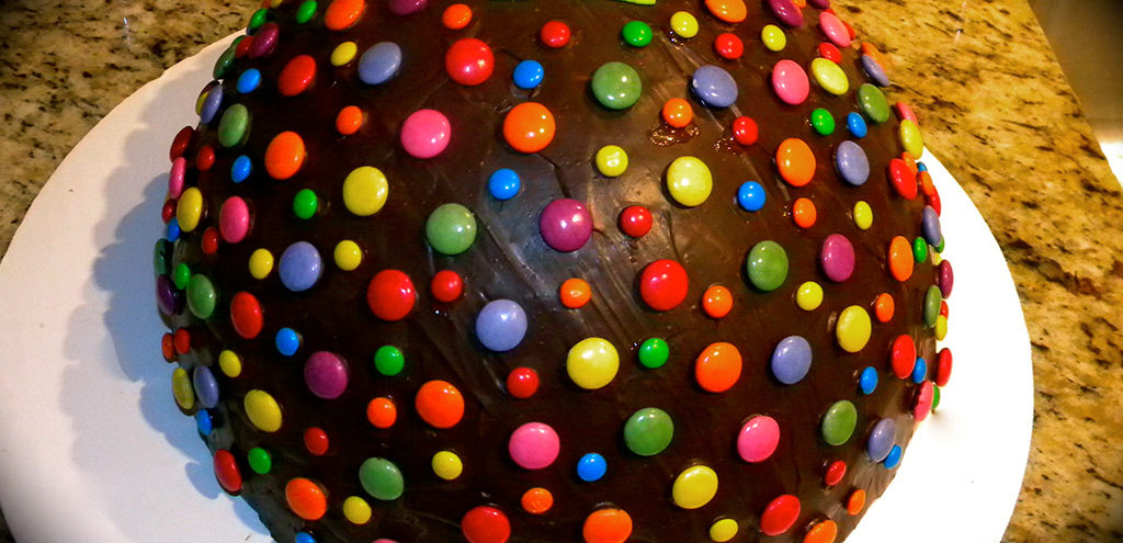 a chocolate dome studded with colourful candies and a number 12