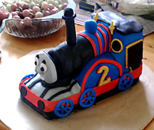 A cake in the shape of a blue steam engine