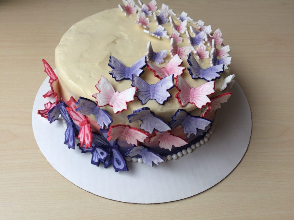 purple and pink sugar butterflies on wedding cake.